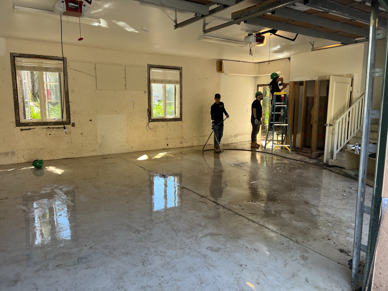 Crew pressure washing floor after demolition cleanup
